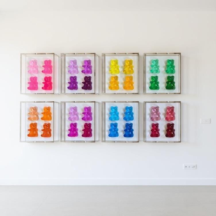 A radiant fusion of nostalgia and modern luxury, this jewel‑tone gummy bear sculpture is meticulously cast in premium resin and displayed within a museum‑grade, UV‑protected shadow box. Each bear glows with gemstone richness—deep sapphire, amethyst, ruby, citrine, or emerald tones—capturing light like a miniature piece of candy‑inspired fine art.